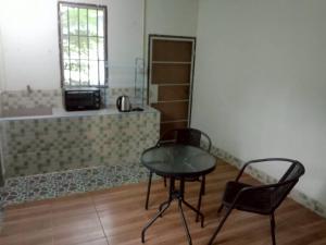 une table et deux chaises dans une pièce dans l'établissement Future house, à Ban Yang Pa Kha