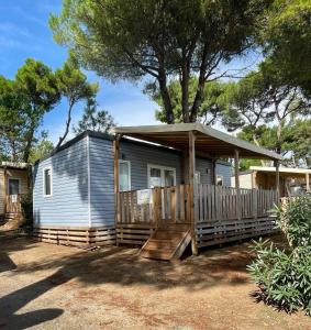 une petite maison avec une terrasse couverte et un kiosque dans l'établissement La Yole Mobilhome Premium 6 pers avec terrasse lounge, à Vendres