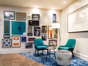 a lobby with two chairs and a table and pictures at Mercure Nottingham Sherwood in Nottingham