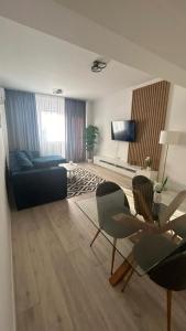 a living room with a couch and chairs and a tv at Mareea Luxury Apartment-Energia Residence in Constanţa