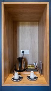 a tea kettle and two cups on a wooden shelf at Chambres d'hôtes du Château de Seguin in Lignan-de-Bordeaux