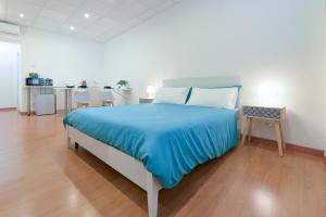 LHE Les Trois Meirvelles - Green Fernando في تشيسينا: غرفة نوم بسرير كبير مع شراشف زرقاء وطاولة