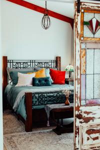 Un dormitorio con una cama con almohadas de colores. en The Werombee Hive, en Theresa Park