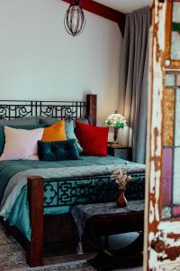 Un dormitorio con una cama con almohadas de colores. en The Werombee Hive, en Theresa Park