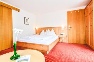 ein Hotelzimmer mit einem Bett und einem Tisch in der Unterkunft Hotel-Pension Hoferhaus in Neukirchen am Großvenediger