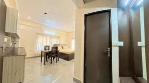 a door to a room with a table and a bedroom at Shri Rudra's Service Apartments in Bhīm Tāl