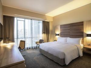 a hotel room with a bed and a large window at Mercure Concepcion in Concepción