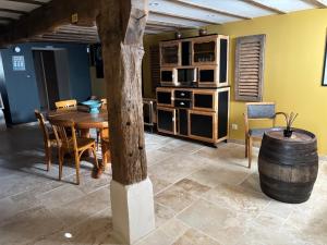 a dining room with a wooden table and chairs at Au Pressoir de Boisy in Pouilly-les-Nonains
