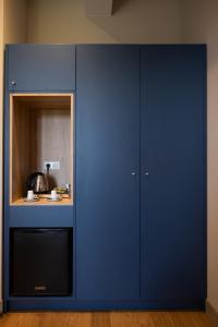 a blue cabinet with a mirror in a room at Chambres d'hôtes du Château de Seguin in Lignan-de-Bordeaux