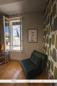 a green couch in a room with a window at Chambres d'hôtes du Château de Seguin in Lignan-de-Bordeaux