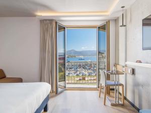 Una habitación de hotel con una cama y vista al océano. en ibis Styles Ajaccio Napoleon, en Ajaccio 83 fotos más