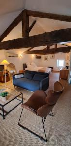 a living room with a blue couch and a bed at La Belle Bourguignonne in Crêches-sur-Saône +18 photos