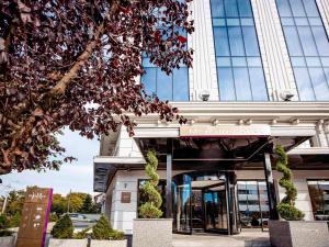 a building with a sign in front of it at Mercure Timisoara in Timişoara