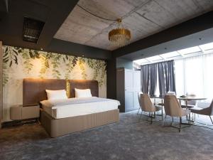 a bedroom with a bed and a table and chairs at Mercure Timisoara in Timişoara