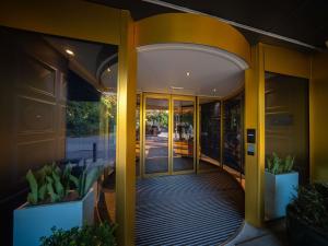 アントワープにあるMaek Hotel Antwerp Central - Handwritten Collectionの黄色の柱と植物のある建物の入り口