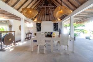 a dining room with a white table and chairs at OMAÏA Private villas in Amed +28 photos