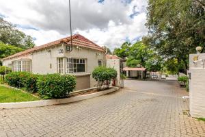 ein weißes Haus auf einer Ziegelstraße mit Büschen in der Unterkunft holiday home away from home1 in Johannesburg