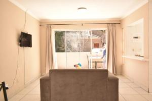 ein Wohnzimmer mit einer Couch und einem Fenster in der Unterkunft holiday home away from home1 in Johannesburg