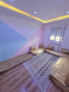a room with a bed and a rug on the floor at Cozy, 15 min from town centre in Sétif