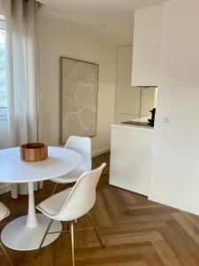 キャヴァレール・シュル・メールにあるStudio moderne centre-ville proche plageのキッチン(白いテーブル、白い椅子付) +5枚の写真