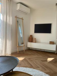 キャヴァレール・シュル・メールにあるStudio moderne centre-ville proche plageの壁に薄型テレビが取り付けられたリビングルーム