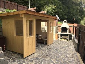 Un cobertizo de madera en un patio con parrilla. en Casa Sonne, en Buşteni