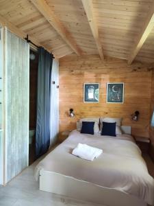 a bedroom with a large bed in a wooden room at Astral in Prunay-Cassereau