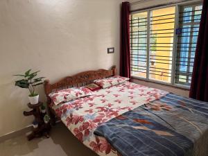 a bedroom with a bed and a window at Swasthiks Home stay in Sakleshpur