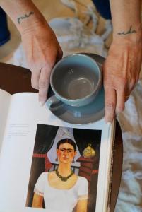 a person holding a book with a cup of coffee at Casa Frida in Villa Carlos Paz