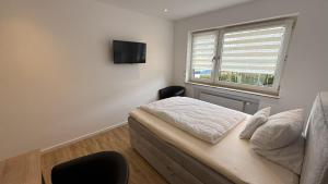 Un dormitorio con una cama y un televisor en la pared. en Gästehaus Fries, en Blankenheim