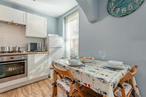 a kitchen with a table with two chairs and a tablecloth at Hideaway in Swanage +15 photos