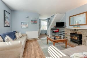 a living room with a couch and a fireplace at Hideaway in Swanage