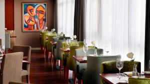 a restaurant with tables and chairs with wine glasses at Garden Hills Hotel in Addis Ababa