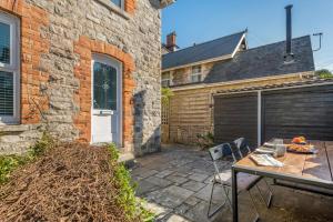 a patio with a table and chairs next to a building at Hideaway in Swanage
