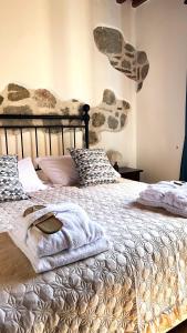 a bedroom with a large bed with blankets and pillows at Villa Tiberini - Wine Relais in Torrita di Siena