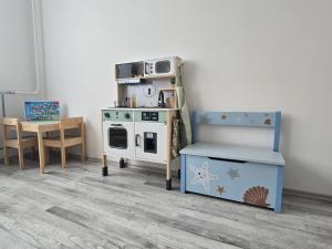 una stanza per bambini con una stufa giocattolo e un tavolo di Comfort 18 Real Family Home a Miskolc