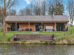 a log cabin next to a body of water at 3 Bed in Cullompton 94139 in Cullompton
