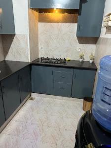 ラーワルピンディーにあるCozy Villa'sのキッチン(青いキャビネット、コンロ付)