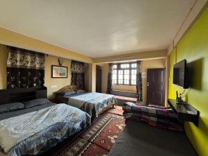 Una habitación de hotel con dos camas y un televisor de pantalla plana. en Nembang Family homestay, en Darjeeling
