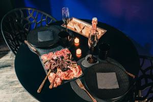 una mesa negra con un plato de comida. en Love Room La Magie d'une Nuit, en Agde 22 fotos más