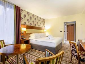 una habitación de hotel con una cama y una mesa en Mercure Liege City Centre, en Lieja
