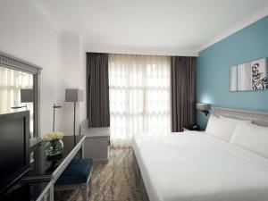 a hotel room with a large bed and a window at Anwar Al Madinah Mövenpick in Al Madinah