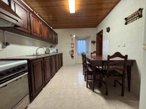 a kitchen with a table and chairs and a sink at Casa da Lúcia in Lajes das Flores
