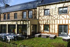 a building with a table and chairs in front of it at Semi-detached house, Rieux in Rieux