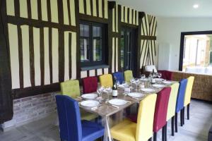 a dining room with a table and colorful chairs at Semi-detached house, Rieux in Rieux