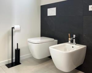 a bathroom with a white toilet and a sink at Sassimori casa vacanza in Chiampo +2 photos