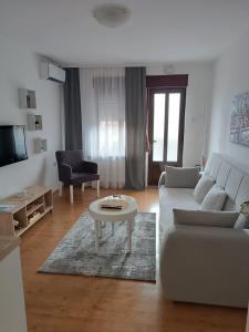 a living room with a couch and a table at Apartman LISA in Niš