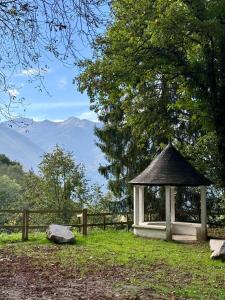 a gazebo in a field with mountains in the background at Résidence Bonnecaze in Eaux-Bonnes