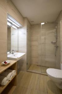 a bathroom with a shower and a sink and a toilet at Hotel Laterum in Pécs
