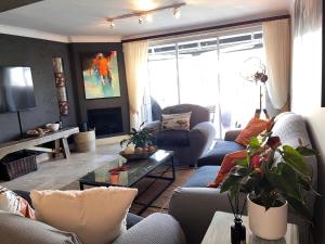 a living room with two couches and a tv at Spinnaker Quays Waterfront Villa in Knysna